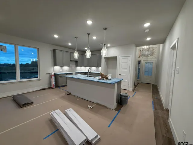 a large kitchen with stainless steel appliances kitchen island granite countertop a refrigerator and a stove top oven with a dishwasher