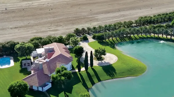 an aerial view of residential houses with outdoor space and lake view
