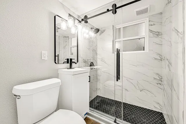 a bathroom with a sink toilet and shower