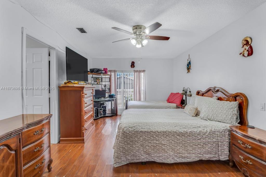 26023 Southwest 133rd Place Homestead, FL 33032 - Photo 15 of 39 a bedroom with a bed and a flat tv screen on the dresser