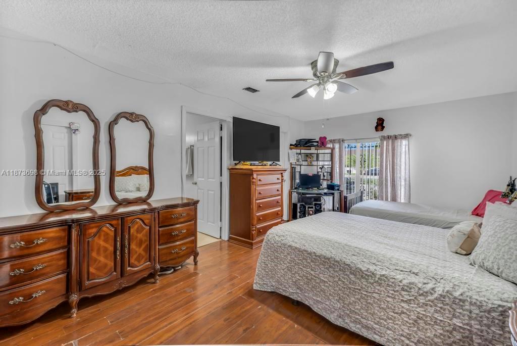 26023 Southwest 133rd Place Homestead, FL 33032 - Photo 16 of 39 a bedroom with a bed a dresser and flat screen tv