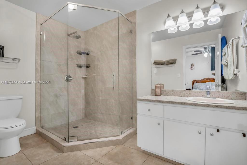 26023 Southwest 133rd Place Homestead, FL 33032 - Photo 17 of 39 a bathroom with a shower sink vanity and mirror