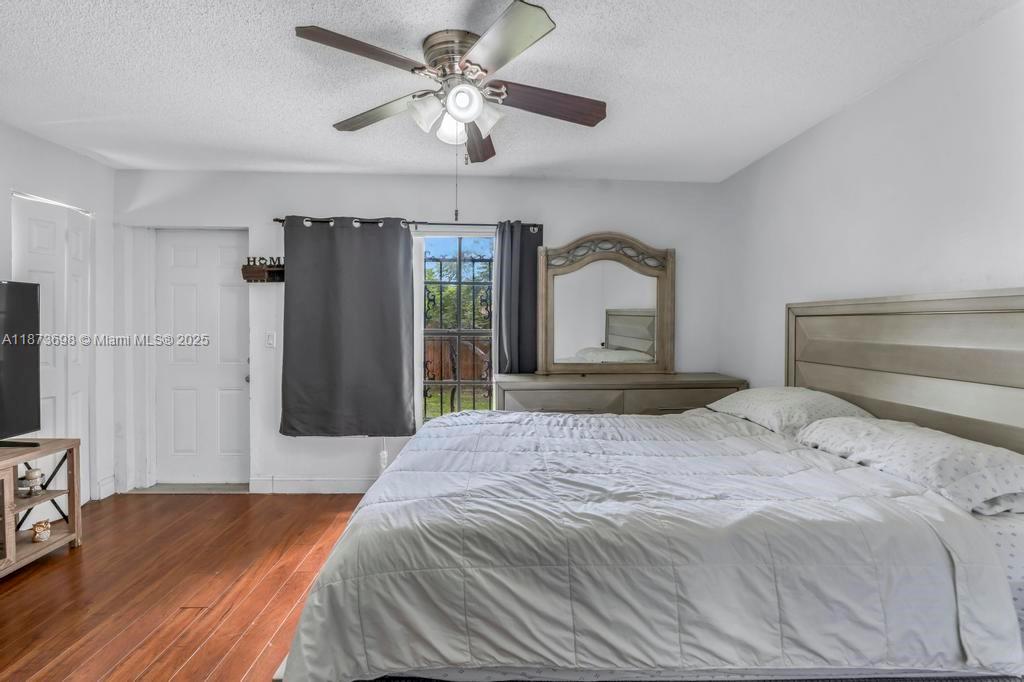 26023 Southwest 133rd Place Homestead, FL 33032 - Photo 22 of 39 a bedroom with a large bed and a chandelier