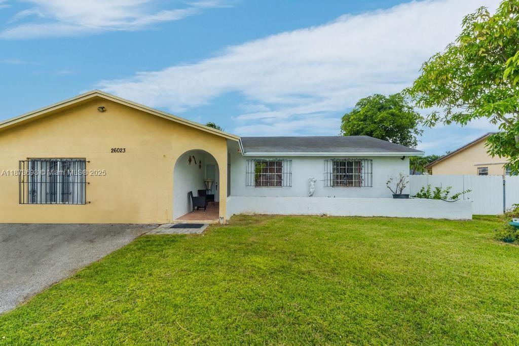26023 Southwest 133rd Place Homestead, FL 33032 - Photo 5 of 39 a front view of house with yard and garage