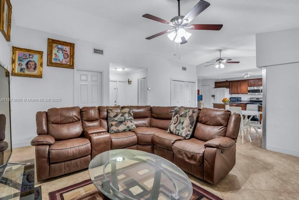 26023 Southwest 133rd Place Homestead, FL 33032 - Photo 8 of 39 a living room with furniture a ceiling fan and a rug