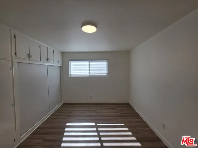 a view of a kitchen with wooden floor and white walls