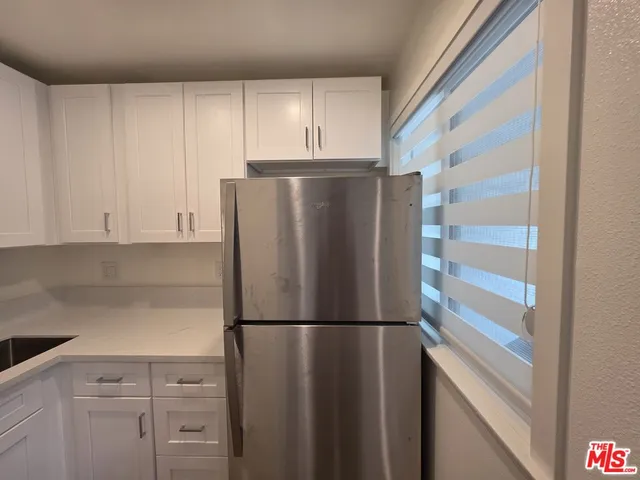 a metallic refrigerator freezer sitting in a kitchen
