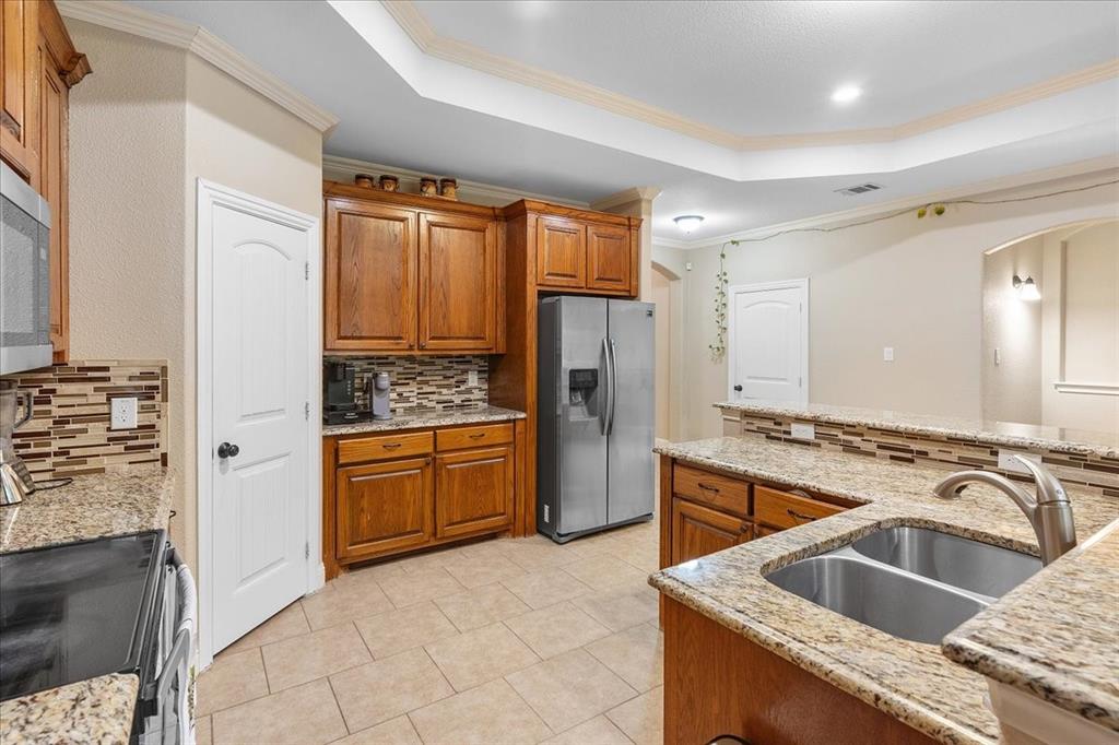 502 Ritchey Street Gainesville, TX 76240 - Photo 11 of 29 a kitchen with granite countertop a sink stove and refrigerator