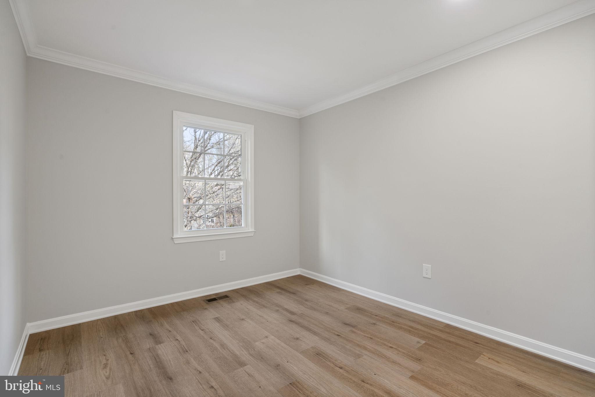 2891 Kelly Square Vienna, VA 22181 - Photo 24 of 39 a view of an empty room with wooden floor and a window