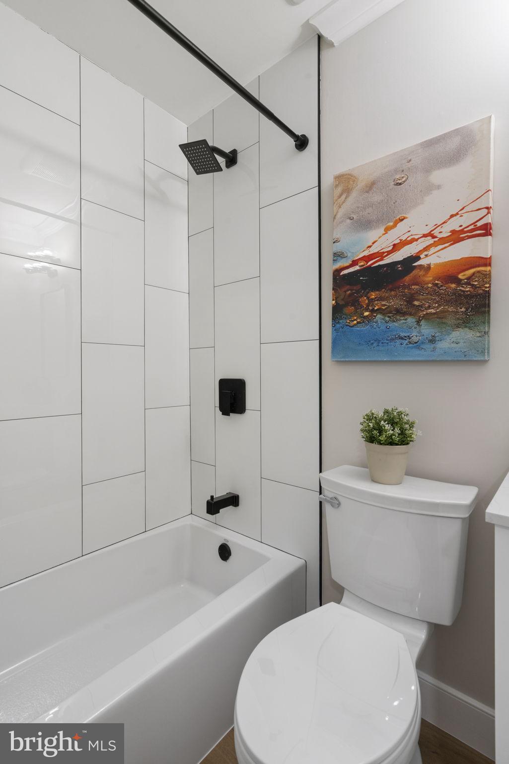 2891 Kelly Square Vienna, VA 22181 - Photo 31 of 39 a white toilet sitting next to a bath tub and a shower