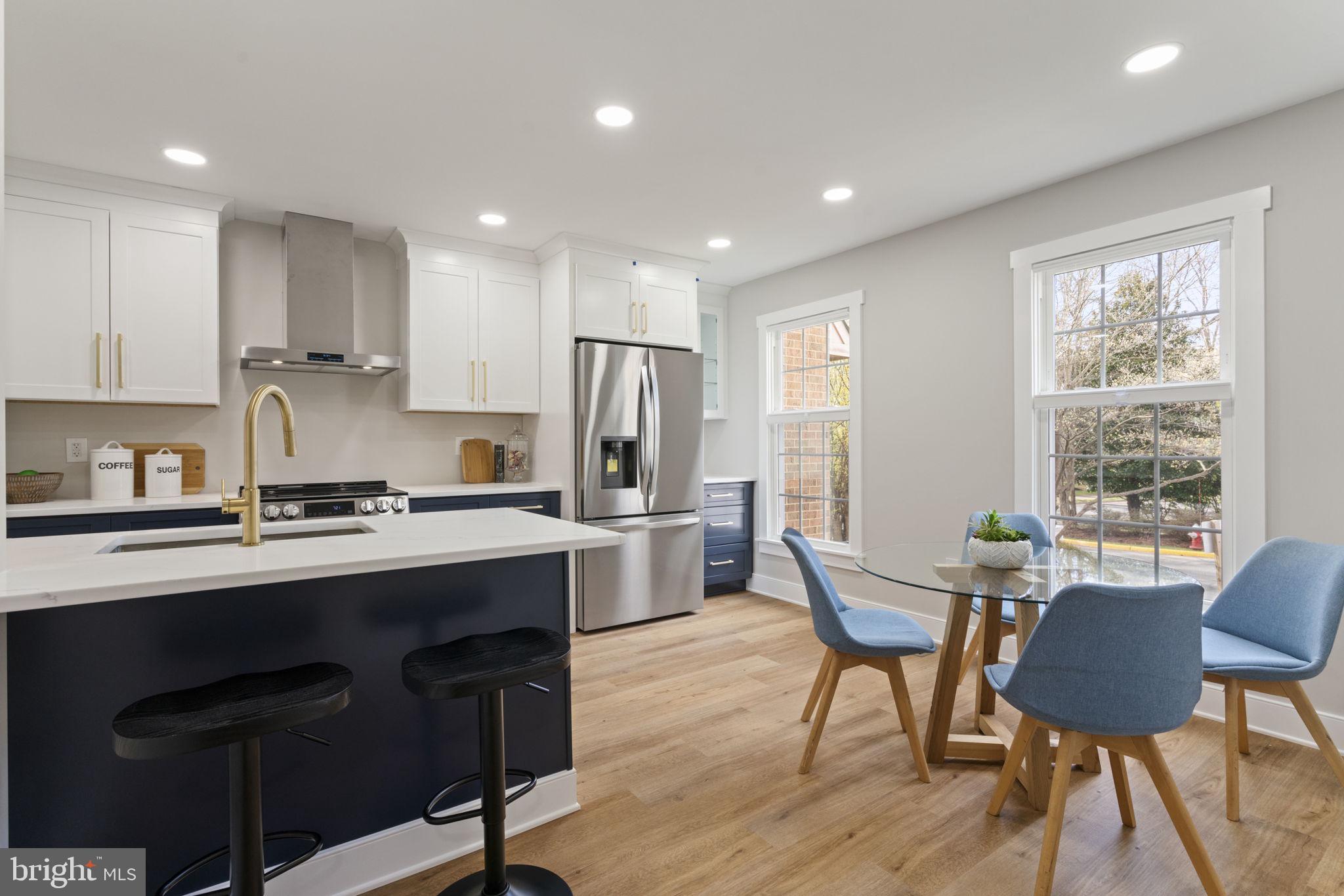 2891 Kelly Square Vienna, VA 22181 - Photo 10 of 39 a kitchen with stainless steel appliances granite countertop a table chairs sink refrigerator and cabinets