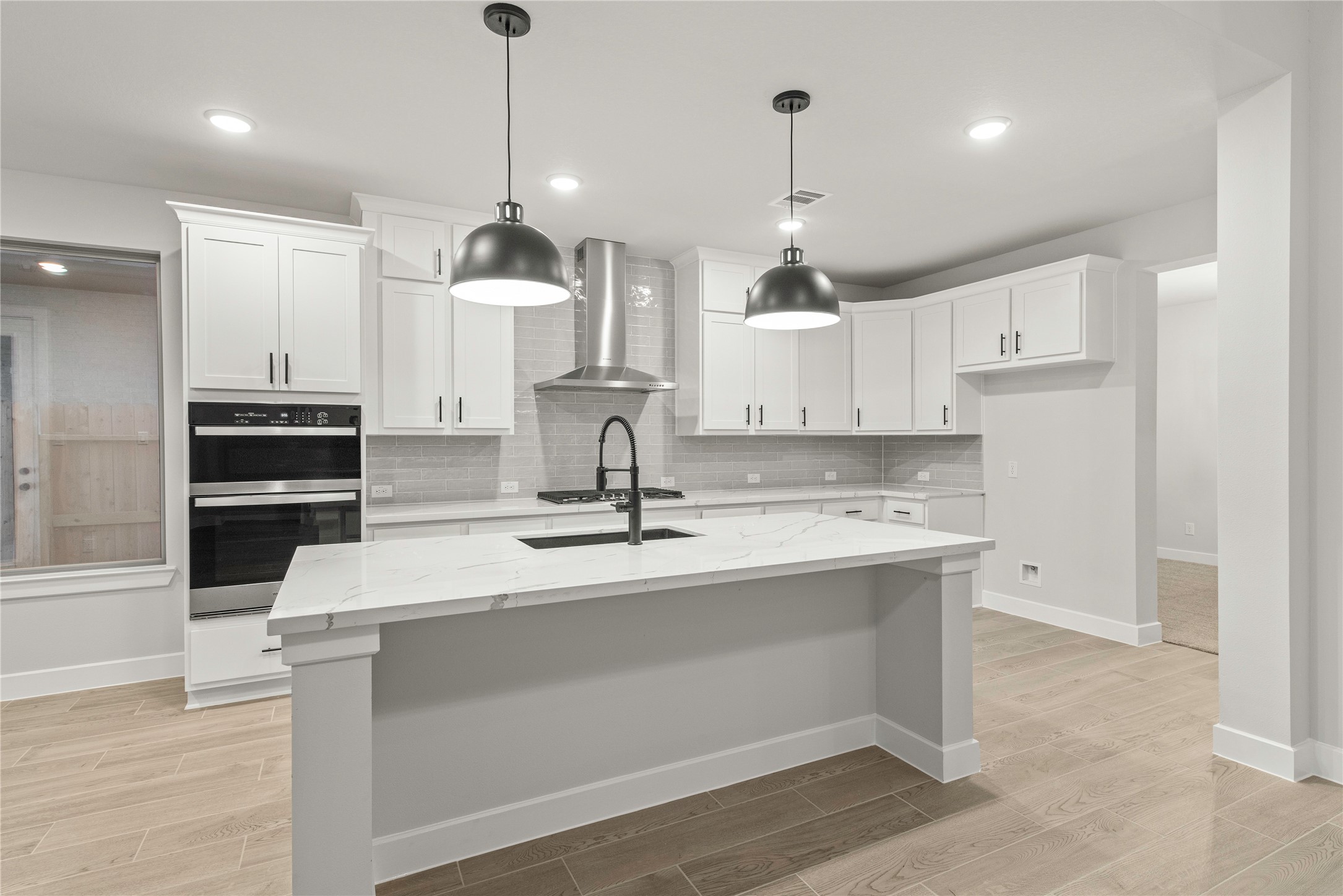 638 Walnut Br Drive Rosenberg, TX 77471 - Photo 6 of 27 a large kitchen with granite countertop a stove a sink a center island and wooden floor