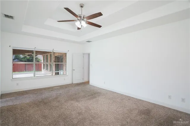 an empty room with a ceiling fan and window
