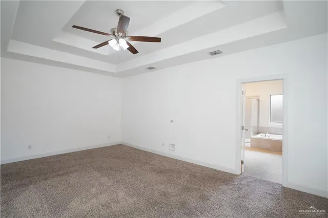 an empty room with a ceiling fan and a window
