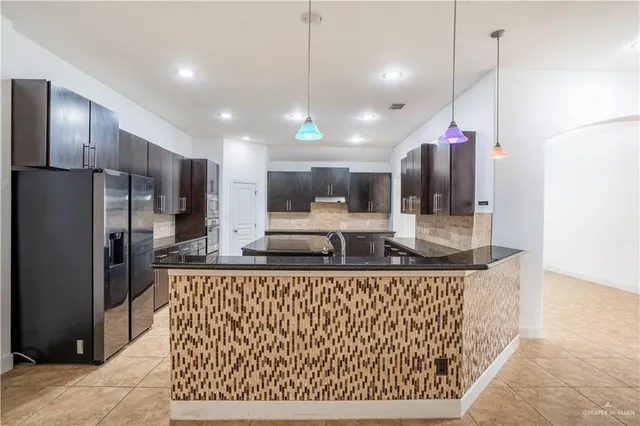 a kitchen with stainless steel appliances granite countertop a sink a refrigerator and a stove