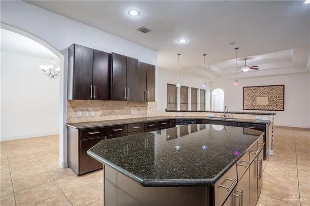 a kitchen with stainless steel appliances granite countertop a sink a center island and chairs