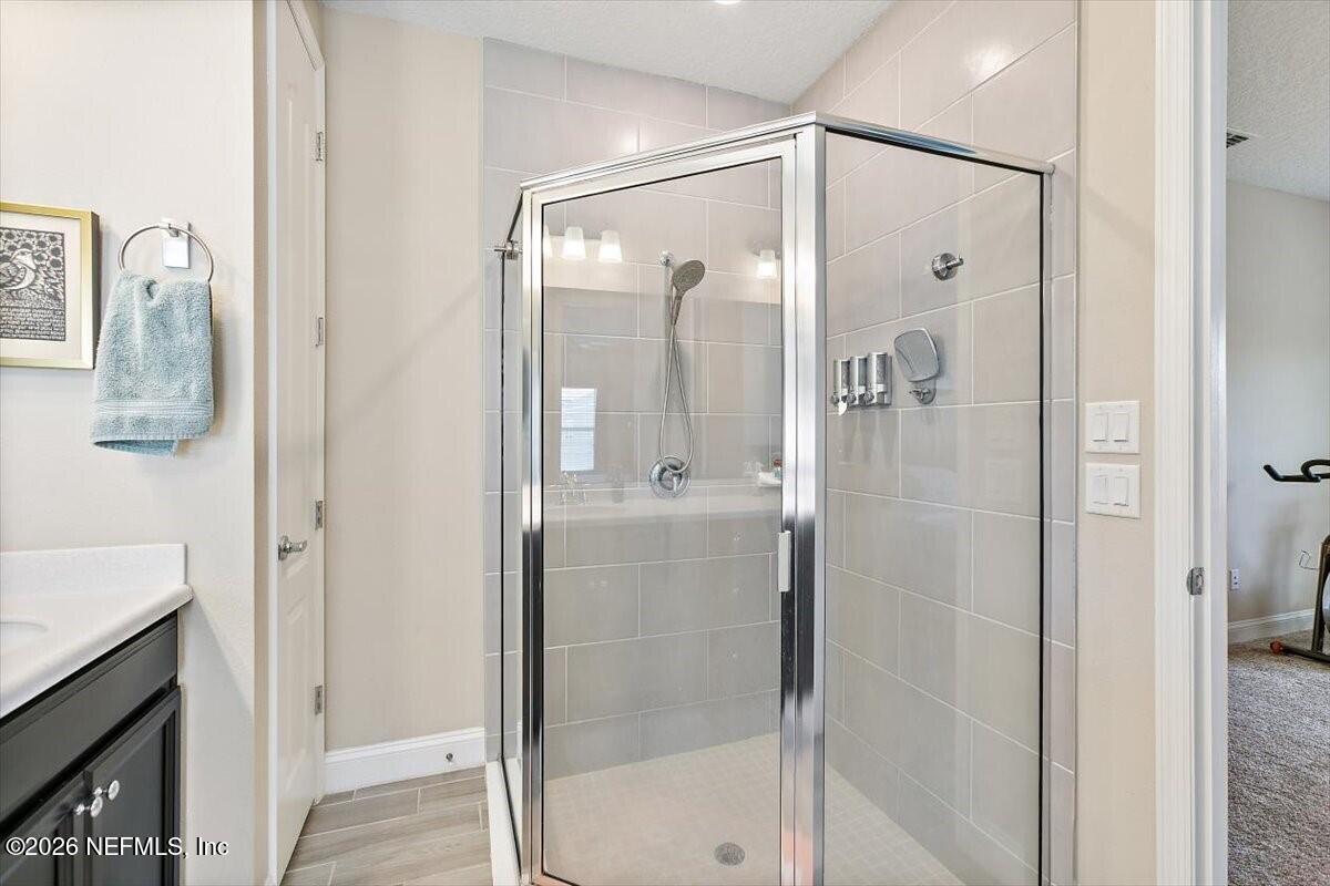 2393 Reese Way Jacksonville, FL 32246 - Photo 12 of 30 a bathroom with a glass shower door and a mirror