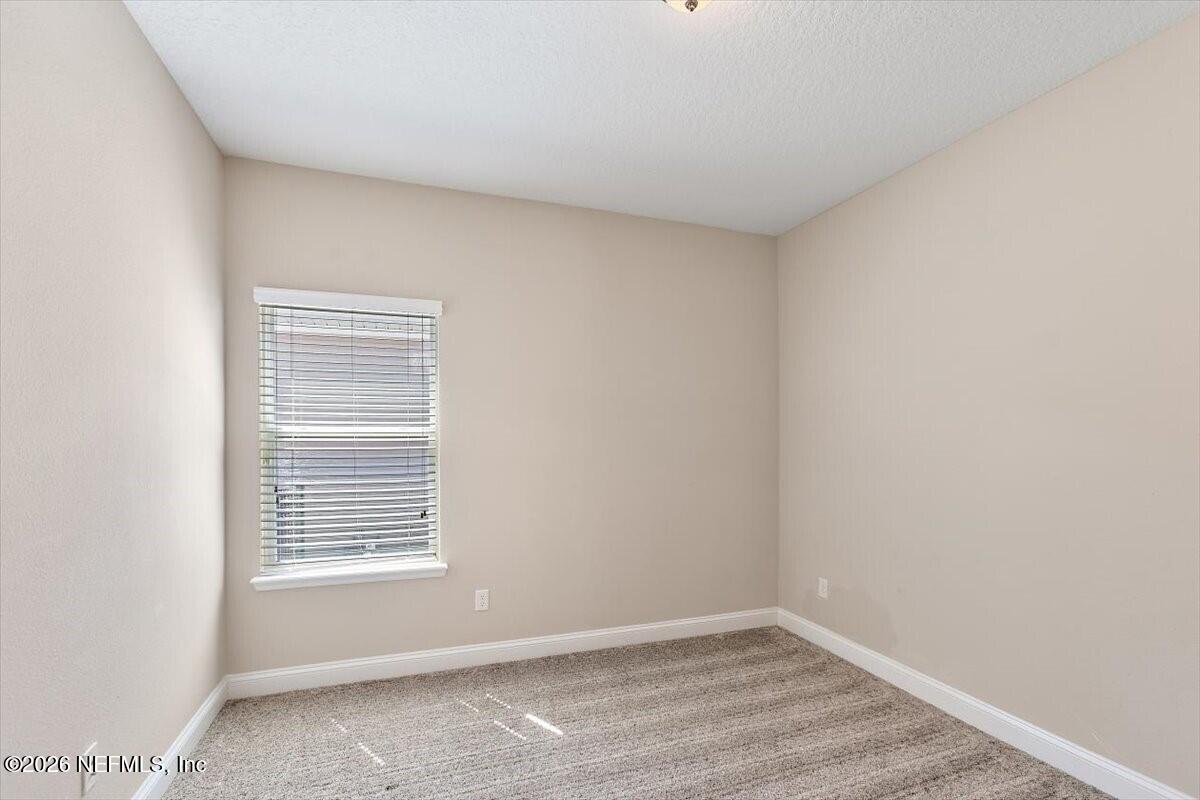 2393 Reese Way Jacksonville, FL 32246 - Photo 15 of 30 a view of an empty room with wooden floor and a window