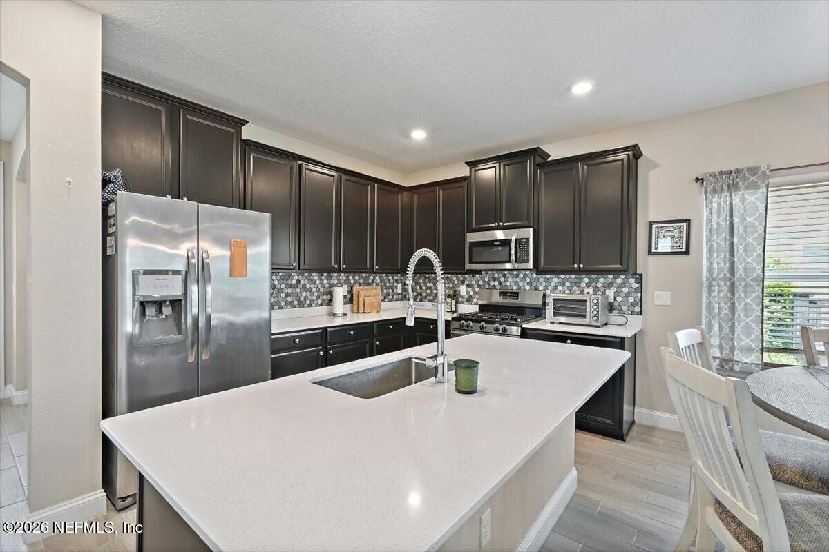 2393 Reese Way Jacksonville, FL 32246 - Photo 7 of 30 a kitchen with stainless steel appliances granite countertop a sink refrigerator and cabinets