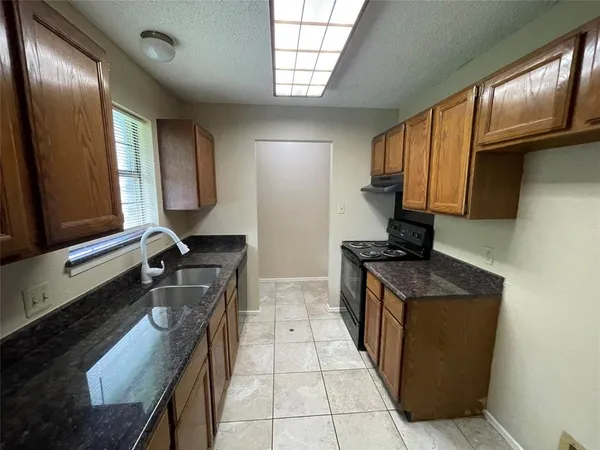 a kitchen with a sink stove top oven and cabinets