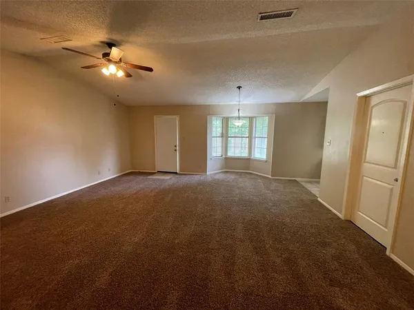 a view of a livingroom with a ceiling fan and window