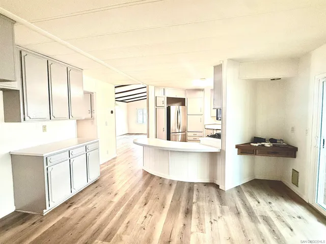 a large white kitchen with kitchen island a stove a sink and a refrigerator