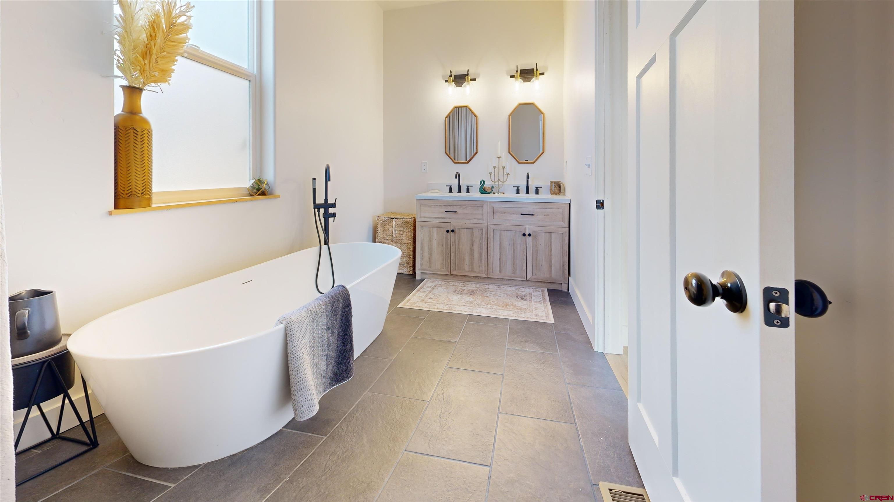 6851 Church Road Olathe, CO 81425 - Photo 17 of 27 a bathroom with a bathtub a sink and a mirror