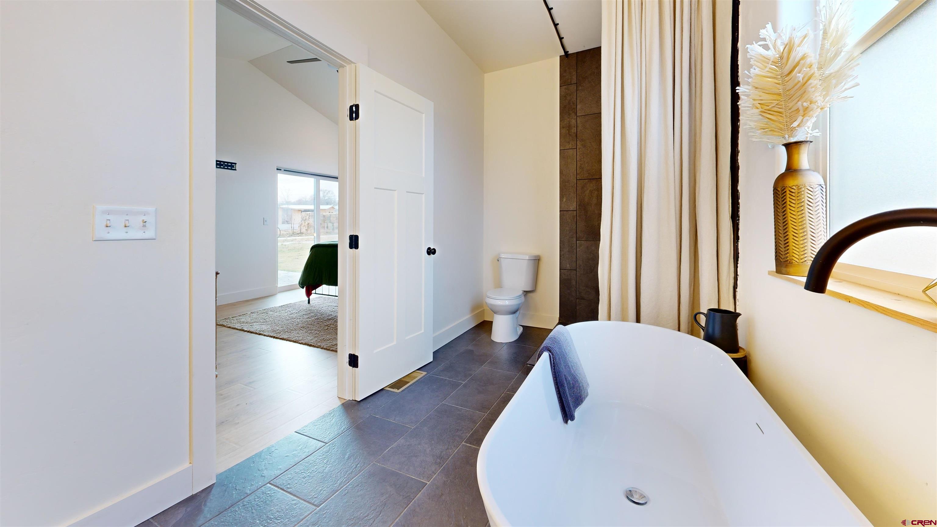 6851 Church Road Olathe, CO 81425 - Photo 20 of 27 a en suite bathroom with a tub and mirror