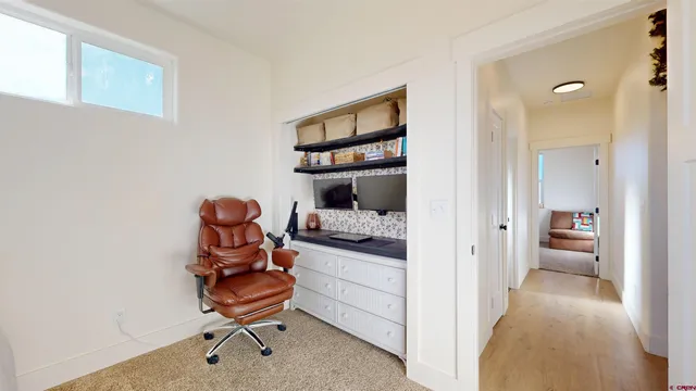 a view of a bedroom with baby bed and lounge chair