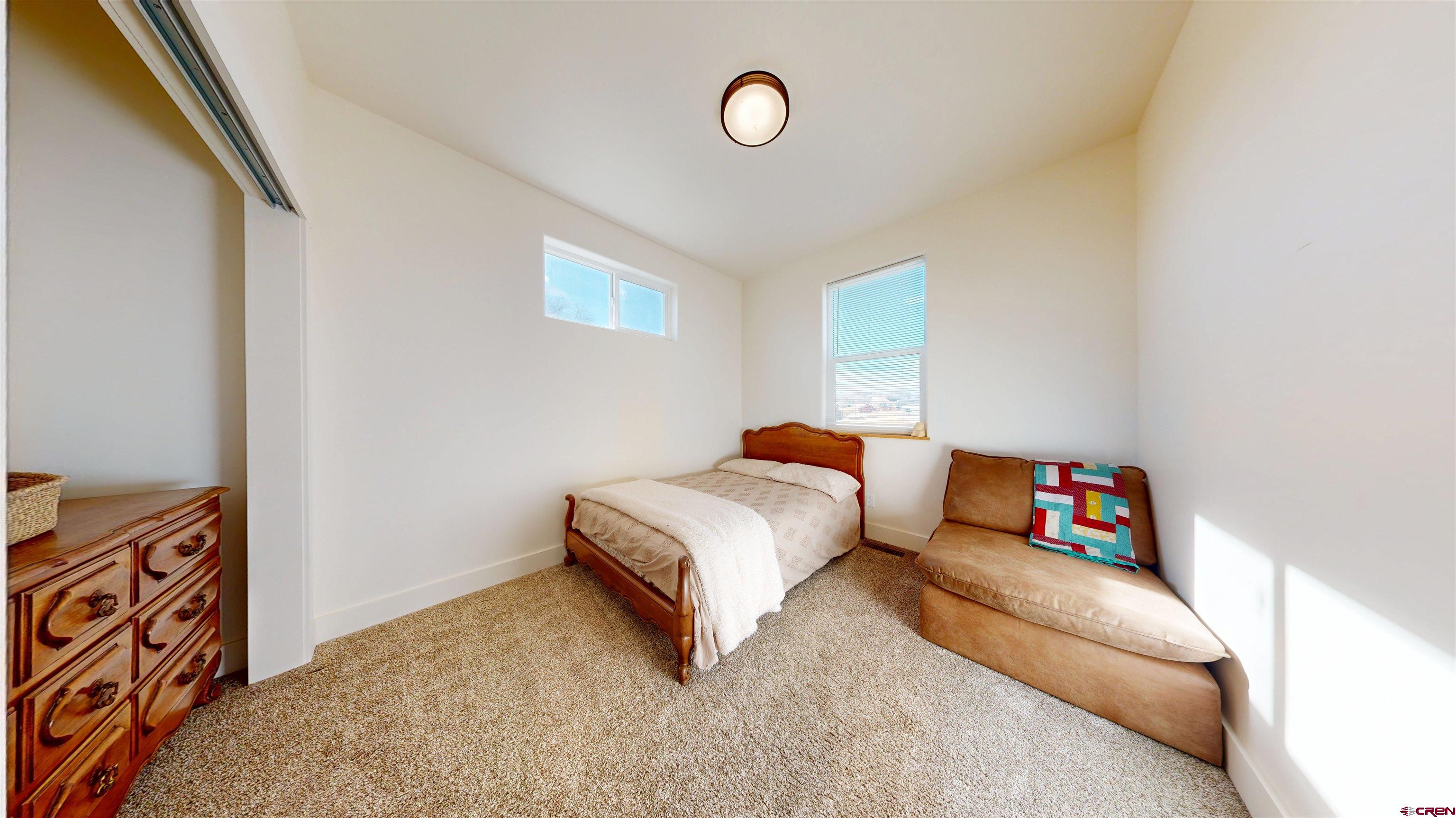 6851 Church Road Olathe, CO 81425 - Photo 23 of 27 a bedroom with a bed and a dresser with wooden floor