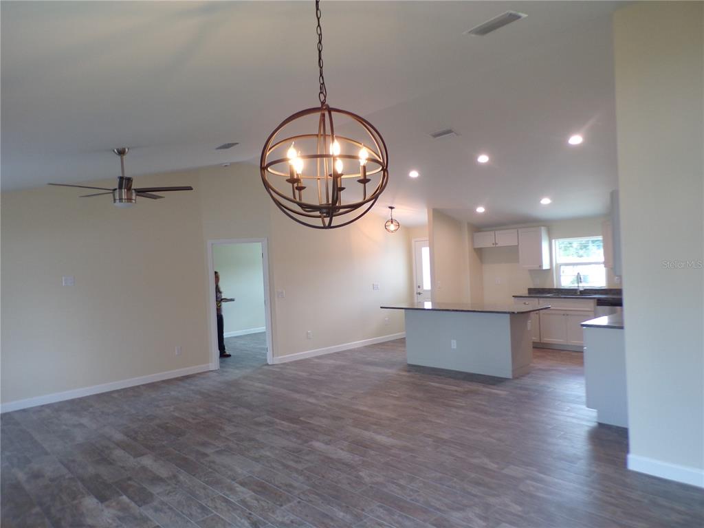 3112 Pinetree Street Port Charlotte, FL 33952 - Photo 11 of 35 an empty room with kitchen view and wooden floor