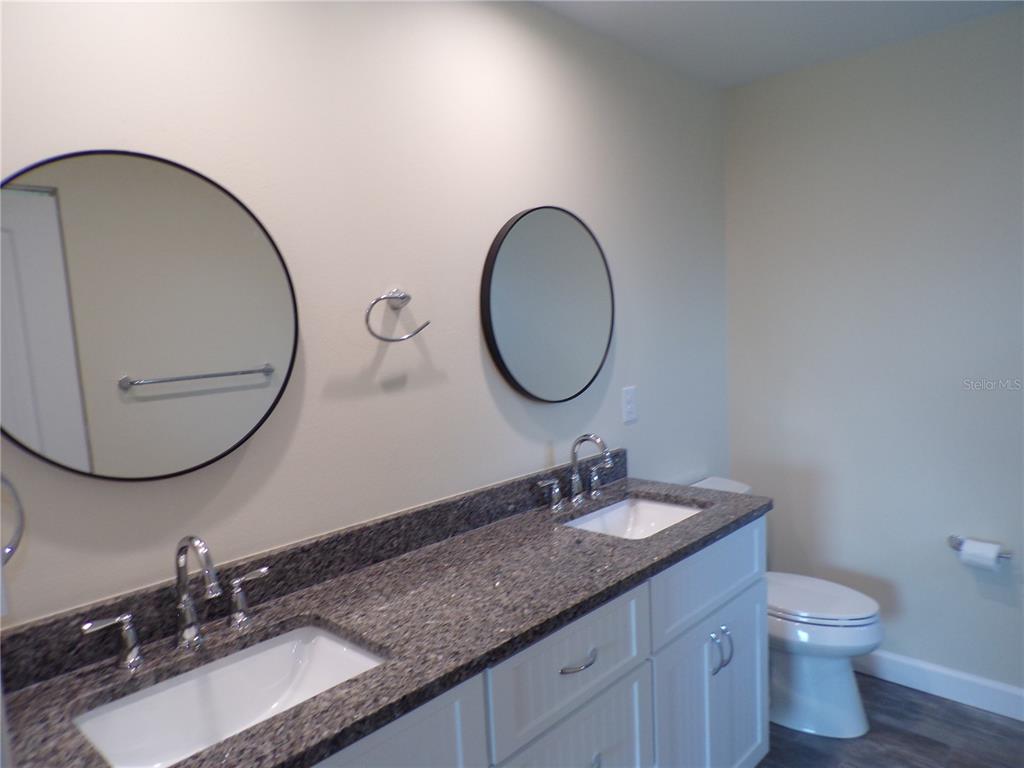 3112 Pinetree Street Port Charlotte, FL 33952 - Photo 12 of 35 a bathroom with a granite countertop double vanity sinks and a mirror