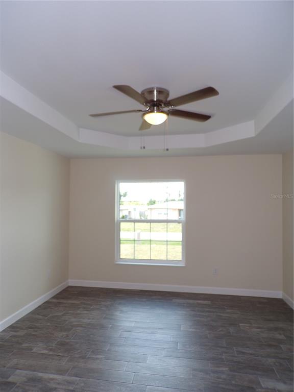 3112 Pinetree Street Port Charlotte, FL 33952 - Photo 13 of 35 an empty room with wooden floor chandelier fan and windows