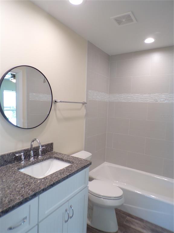 3112 Pinetree Street Port Charlotte, FL 33952 - Photo 17 of 35 a bathroom with a granite countertop sink a toilet and a mirror