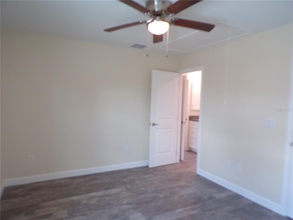 3112 Pinetree Street Port Charlotte, FL 33952 - Photo 18 of 35 an empty room with a window and a fan