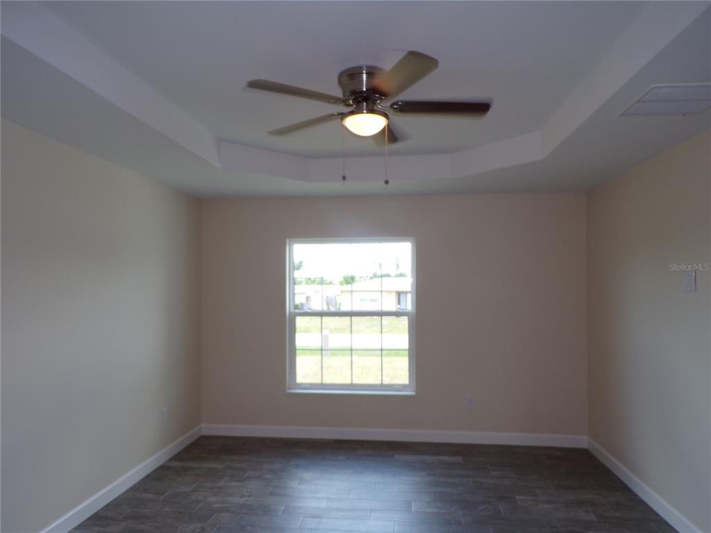 3112 Pinetree Street Port Charlotte, FL 33952 - Photo 7 of 35 an empty room with wooden floor and windows