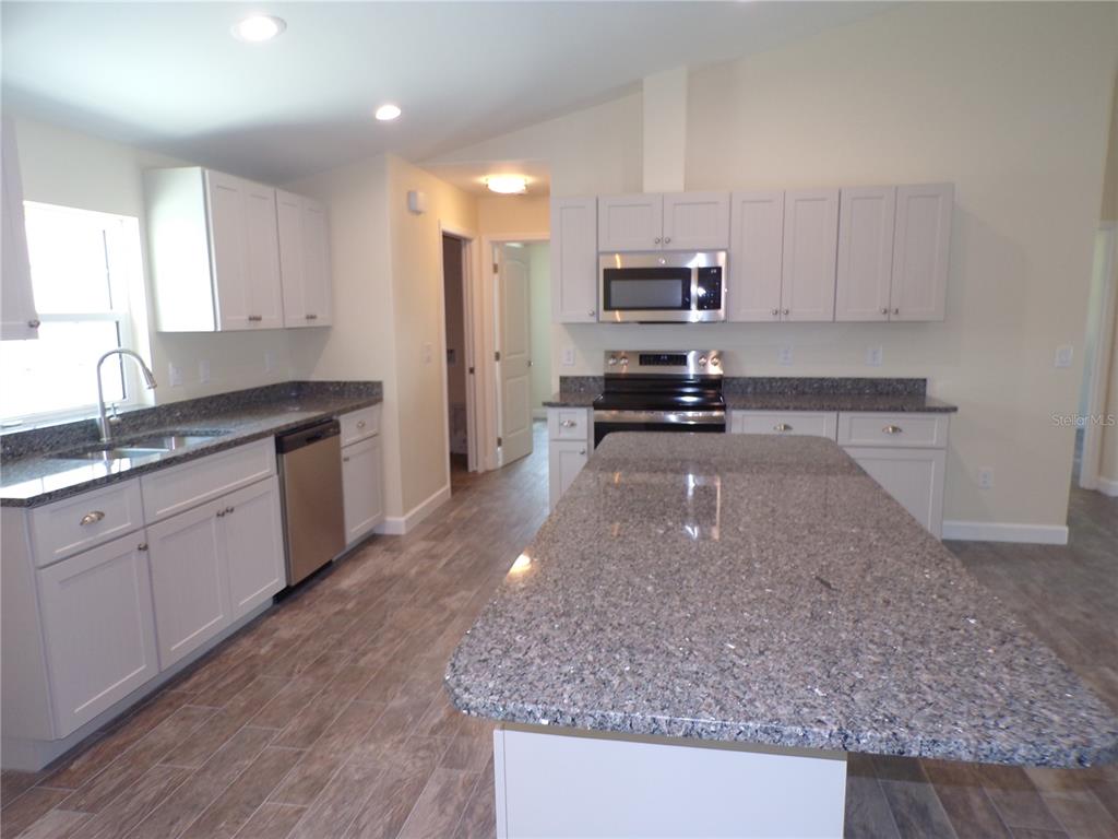 3112 Pinetree Street Port Charlotte, FL 33952 - Photo 8 of 35 a kitchen with a sink a stove a microwave and cabinets