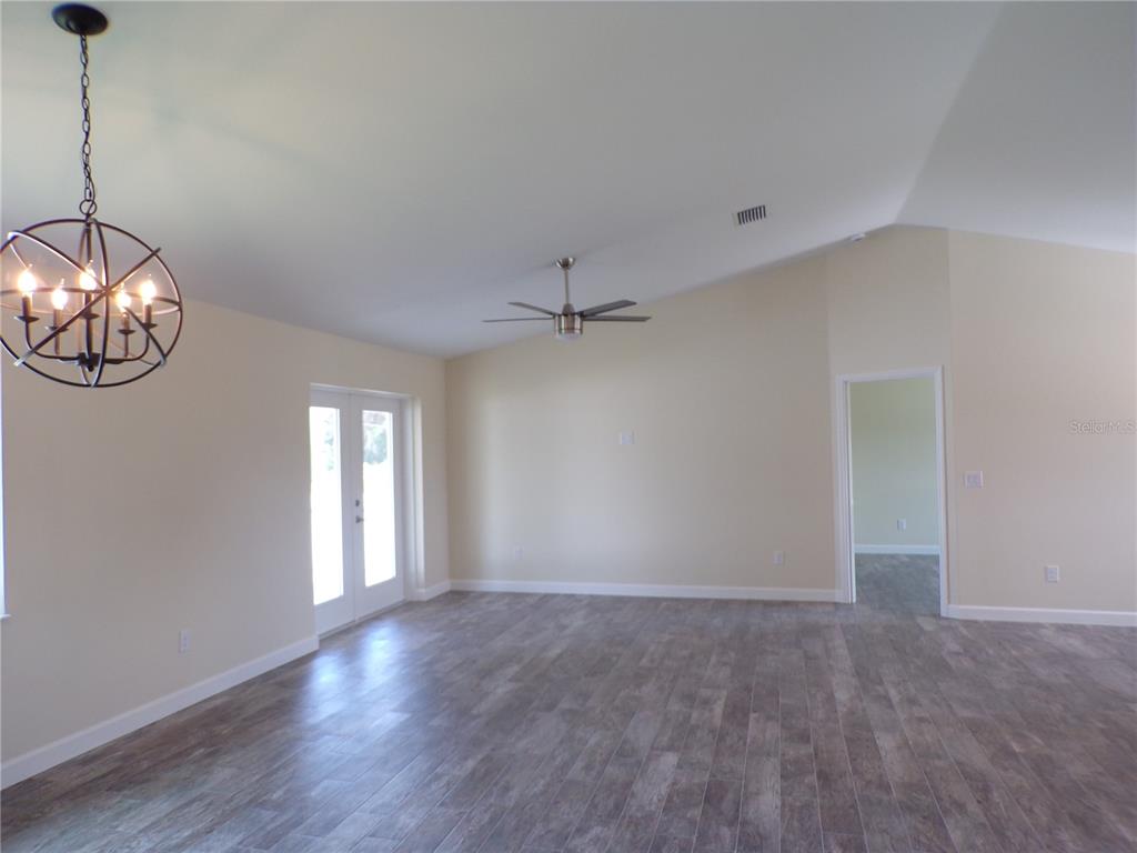 3112 Pinetree Street Port Charlotte, FL 33952 - Photo 9 of 35 a view of an empty room with wooden floor and a window