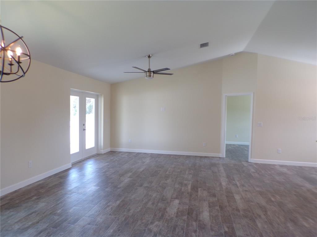 3112 Pinetree Street Port Charlotte, FL 33952 - Photo 10 of 35 a view of an empty room with a window and wooden floor