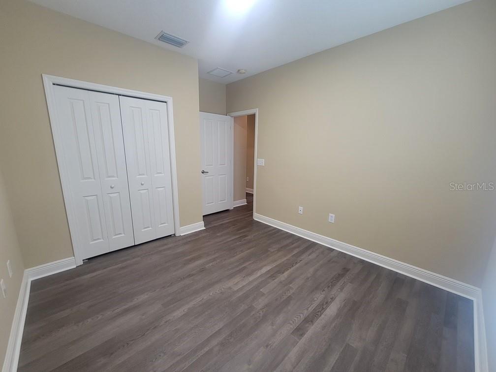 10418 Fenceline Road New Port Richey, FL 34655 - Photo 29 of 36 a view of an empty room with wooden floor