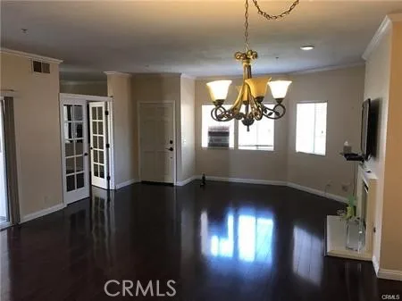 a view of a livingroom with wooden floor and a chandelier