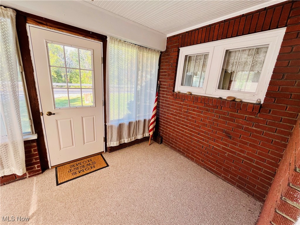 4704 South Ridge Road East Geneva, OH 44041 - Photo 14 of 49 Doorway to outside featuring brick wall and carpet