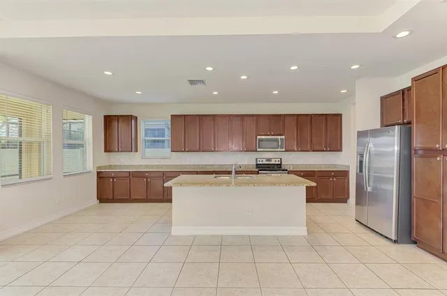 a kitchen with stainless steel appliances a refrigerator a stove a sink and a refrigerator