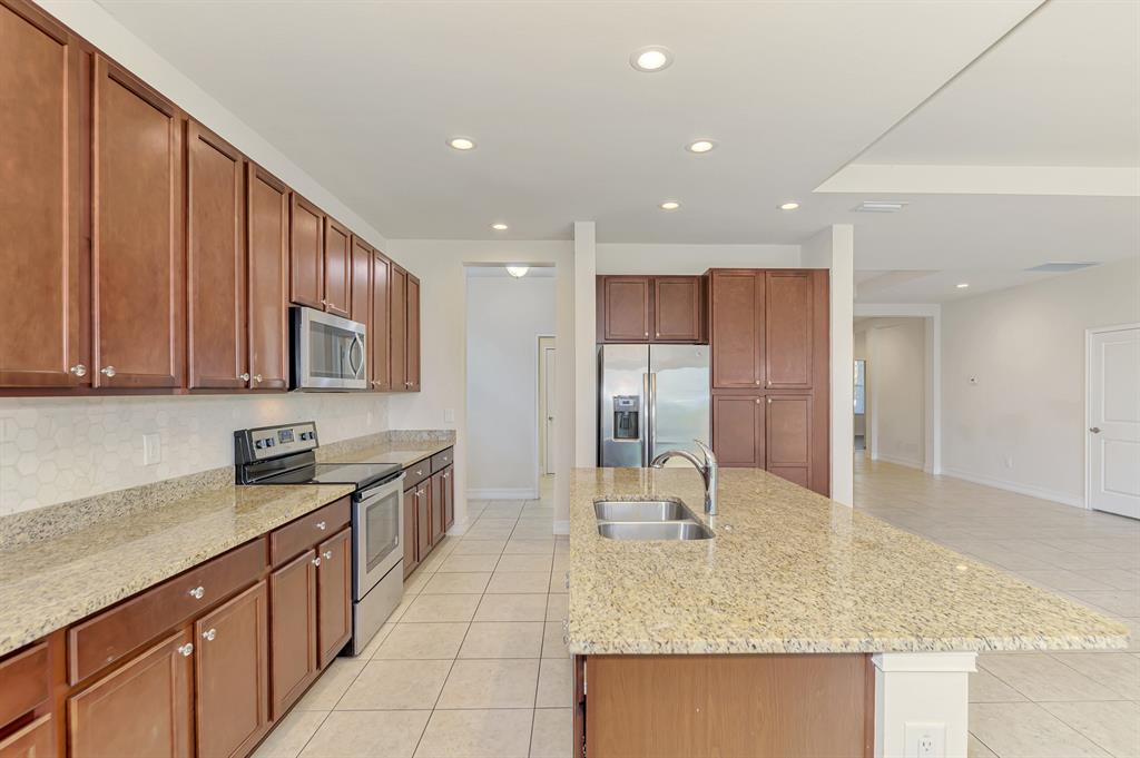 4429 Conchfish Lane Osprey, FL 34229 - Photo 17 of 39 a kitchen with stainless steel appliances granite countertop a sink stove and cabinets