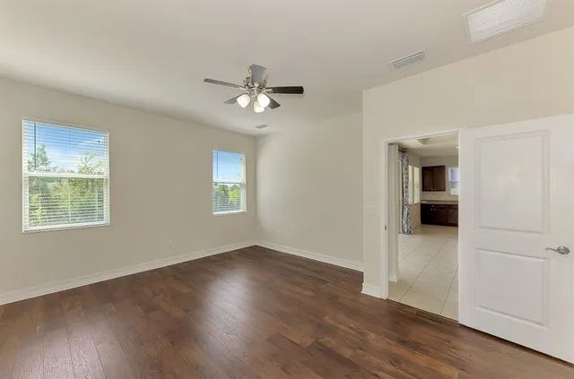 a view of a livingroom with wooden floor and a ceiling fan