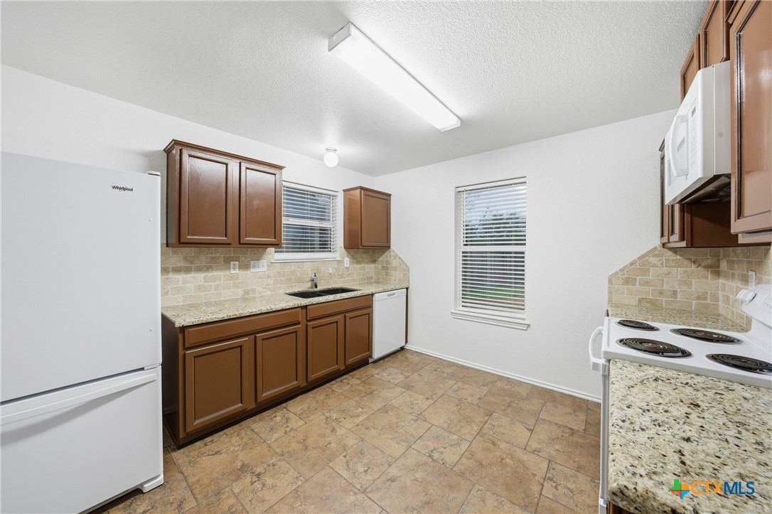 6525 Brooks Drive Temple, TX 76502 - Photo 14 of 37 a large kitchen with stainless steel appliances granite countertop a sink stove and refrigerator
