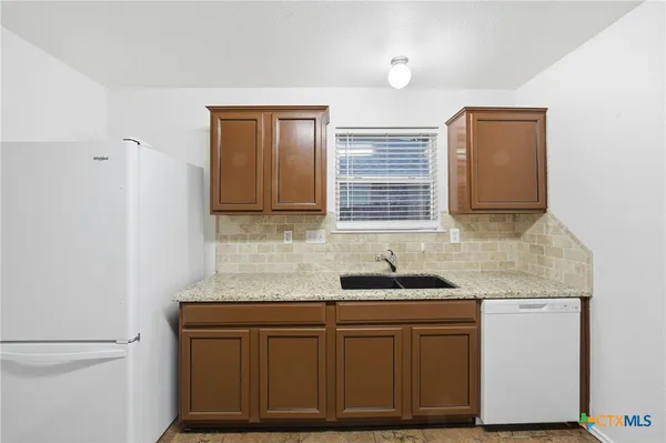 a kitchen with granite countertop cabinets sink and window