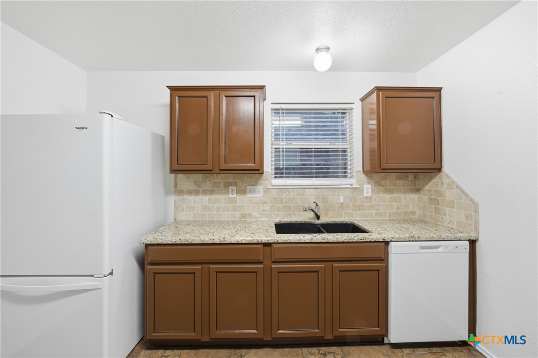 6525 Brooks Drive Temple, TX 76502 - Photo 15 of 37 a kitchen with granite countertop cabinets sink and window