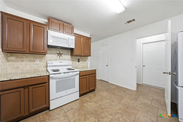 a kitchen with a sink stove and cabinets