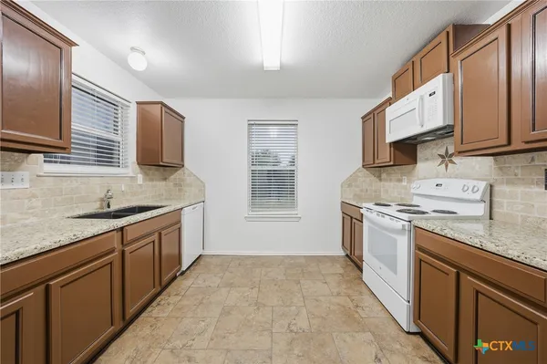 a kitchen with stainless steel appliances granite countertop a sink stove and cabinets